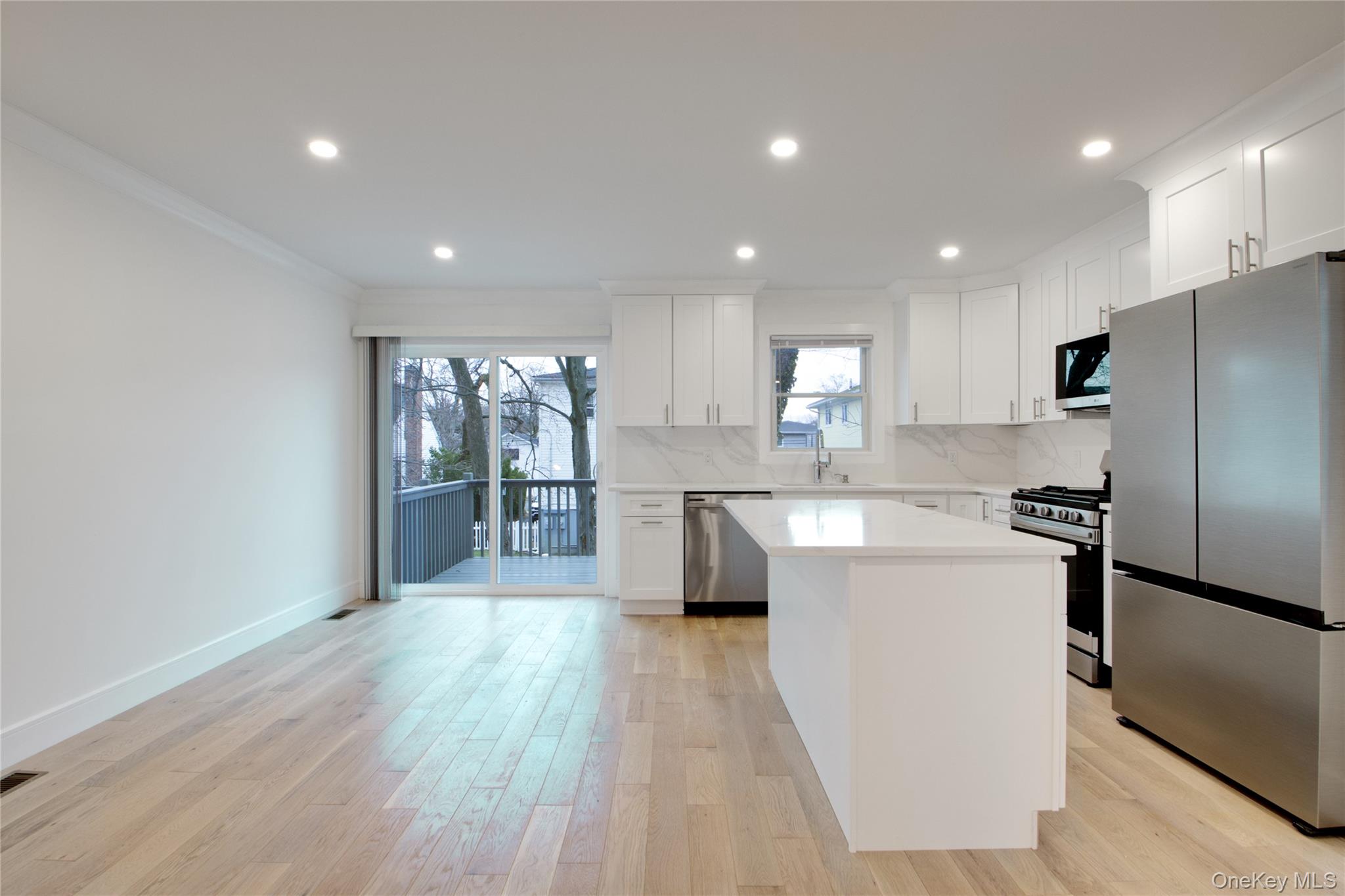 56 Kirkwood Road Port Washington, NY 11050 - Photo 14 of 46 a kitchen with stainless steel appliances granite countertop a refrigerator a sink dishwasher and a oven with wooden floors