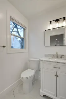 a bathroom with a toilet a sink and mirror