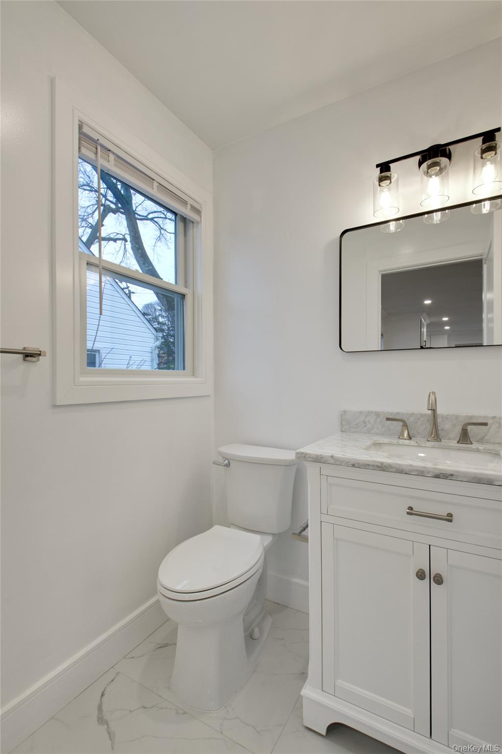 56 Kirkwood Road Port Washington, NY 11050 - Photo 15 of 46 a bathroom with a toilet a sink and mirror