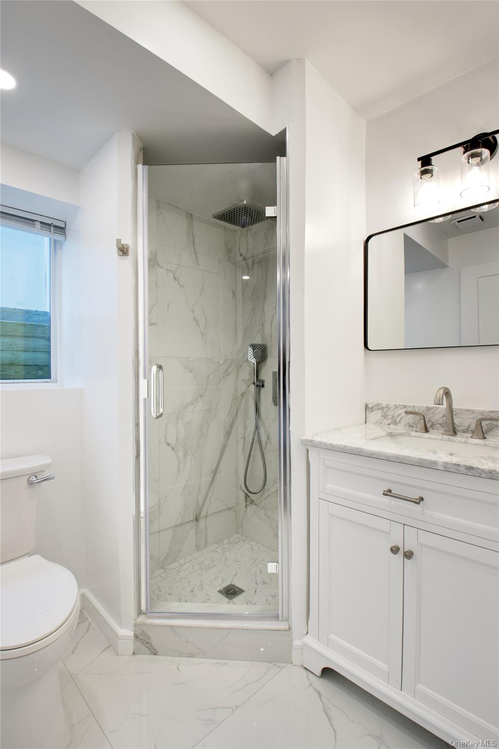 56 Kirkwood Road Port Washington, NY 11050 - Photo 17 of 46 a bathroom with a granite countertop sink a toilet and shower