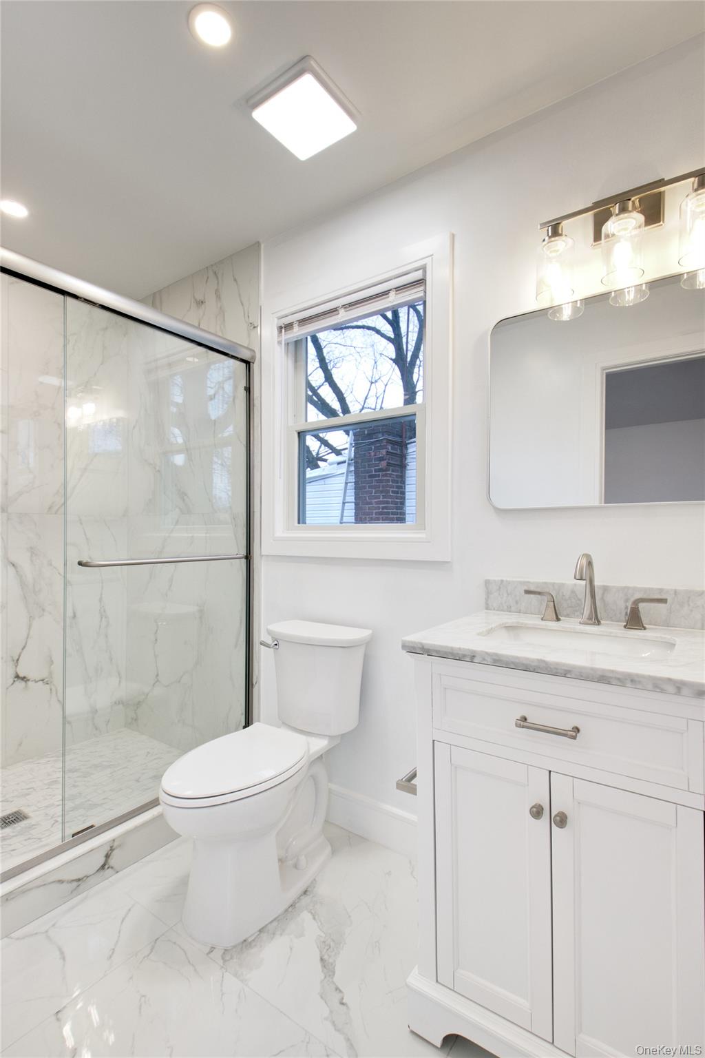 56 Kirkwood Road Port Washington, NY 11050 - Photo 32 of 46 a bathroom with a granite countertop sink toilet a mirror and shower