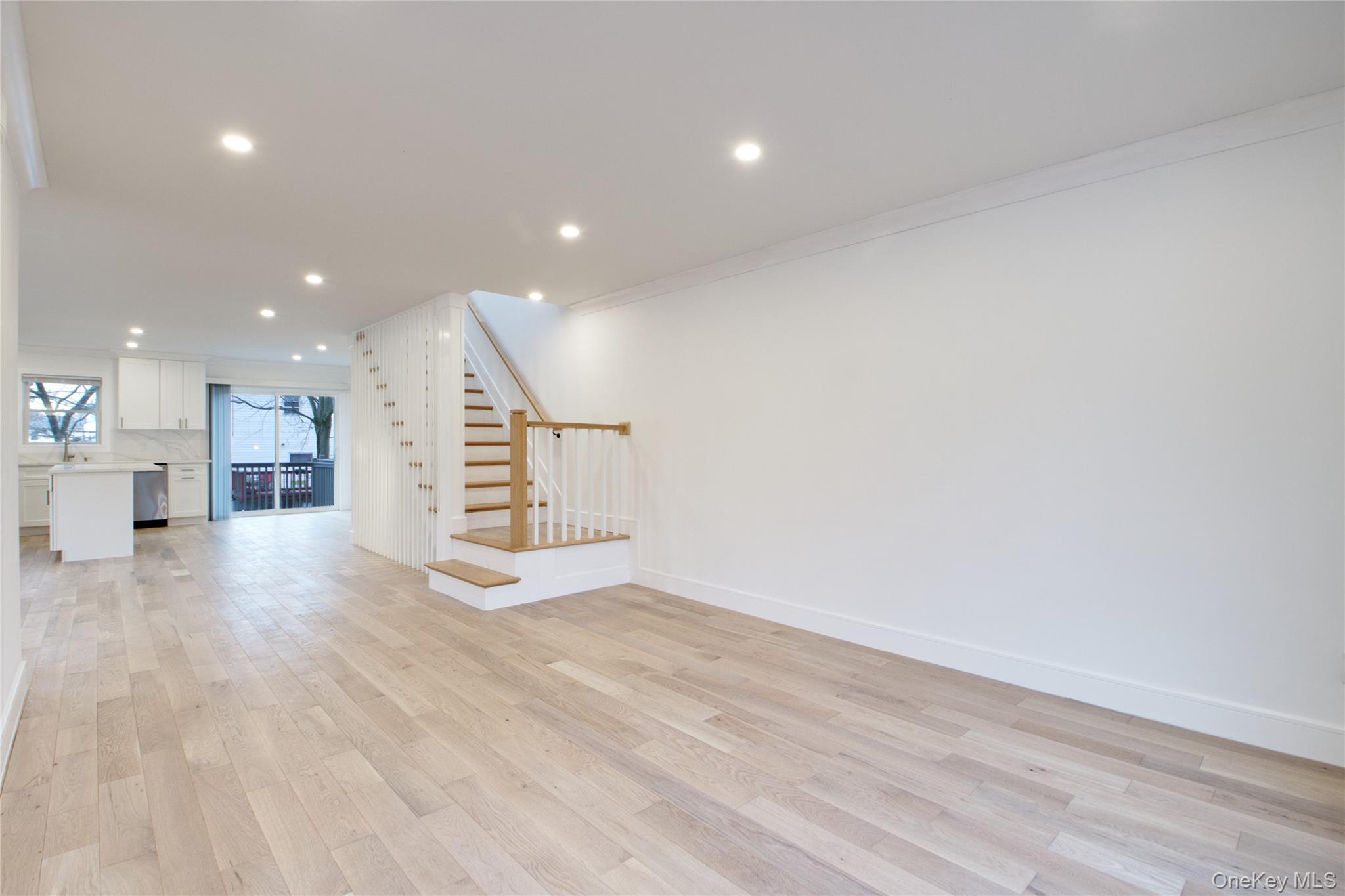56 Kirkwood Road Port Washington, NY 11050 - Photo 35 of 46 a view of an empty room with wooden floor and a kitchen
