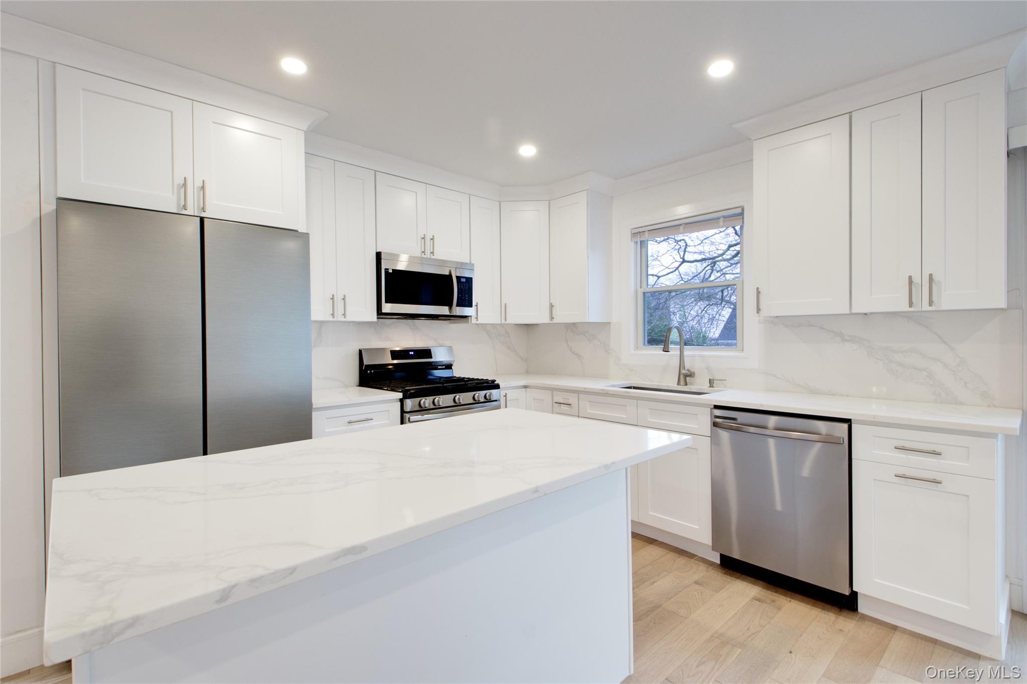 56 Kirkwood Road Port Washington, NY 11050 - Photo 40 of 46 a kitchen with stainless steel appliances a refrigerator stove microwave and sink