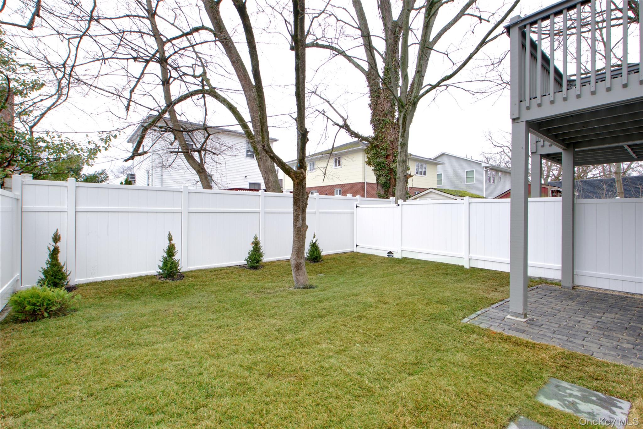 56 Kirkwood Road Port Washington, NY 11050 - Photo 43 of 46 a backyard of a house with table and chairs