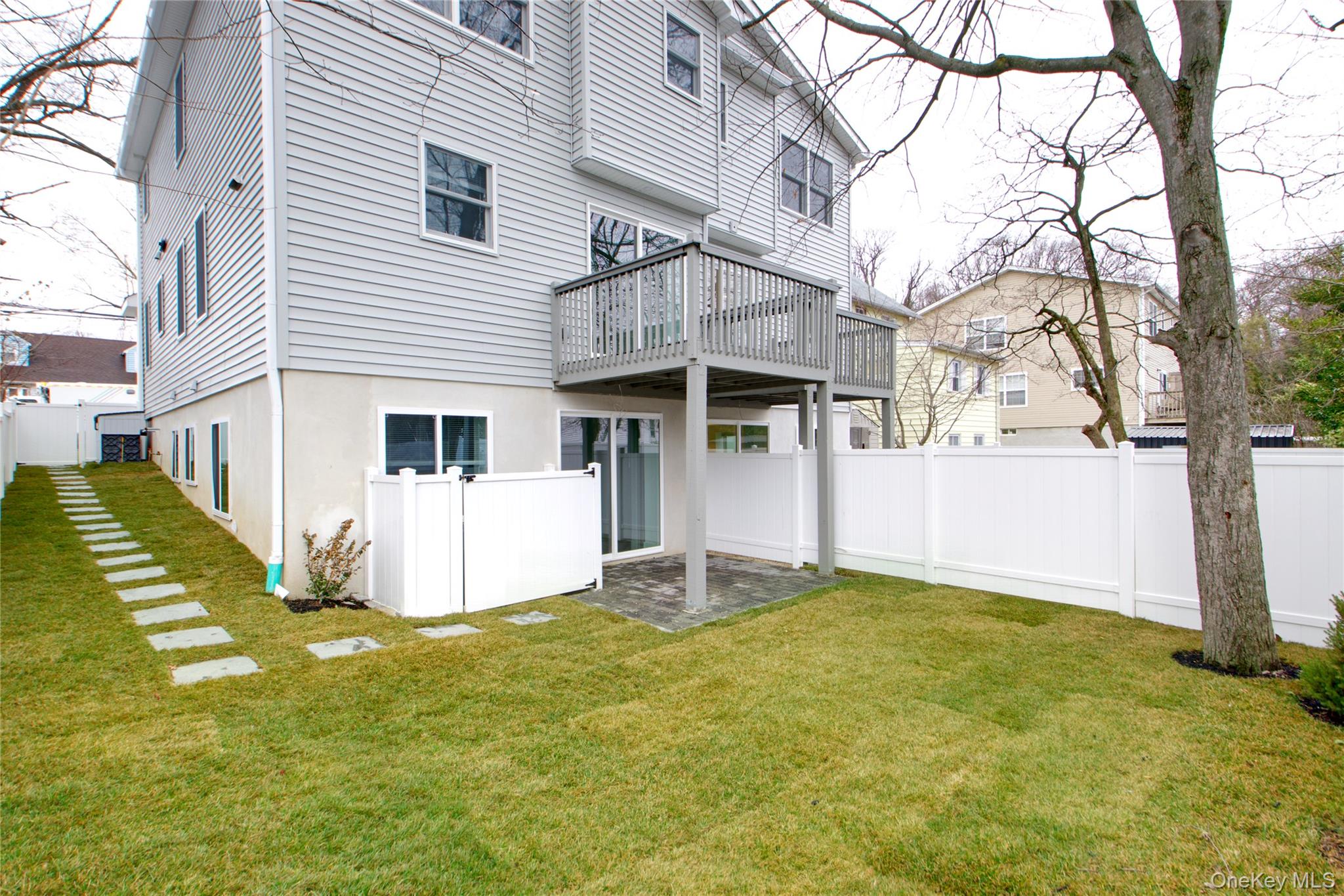 56 Kirkwood Road Port Washington, NY 11050 - Photo 45 of 46 a white house that has a tree in front of it