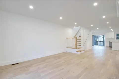 a view of a hall with wooden floor and a window