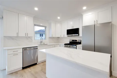 a kitchen with stainless steel appliances a refrigerator sink and microwave
