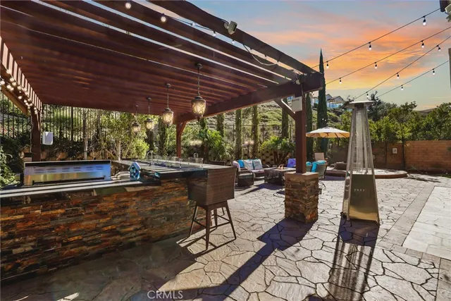 a view of a patio with couches table and chairs with wooden floor and fence