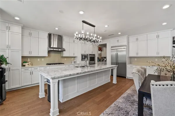 a kitchen with kitchen island granite countertop a sink stove and refrigerator