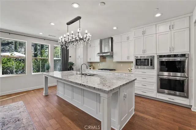 a kitchen with kitchen island granite countertop a stove and a wooden floors