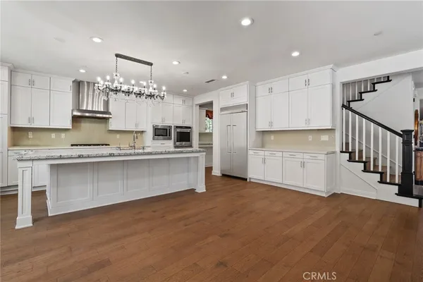 a large white kitchen with cabinets a sink and a stove