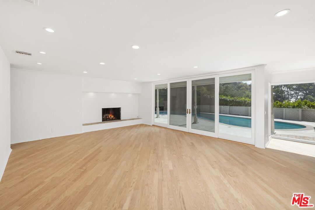 1700 Rising Glen Road Los Angeles, CA 90069 - Photo 4 of 19 a view of an empty room with a fireplace and a window