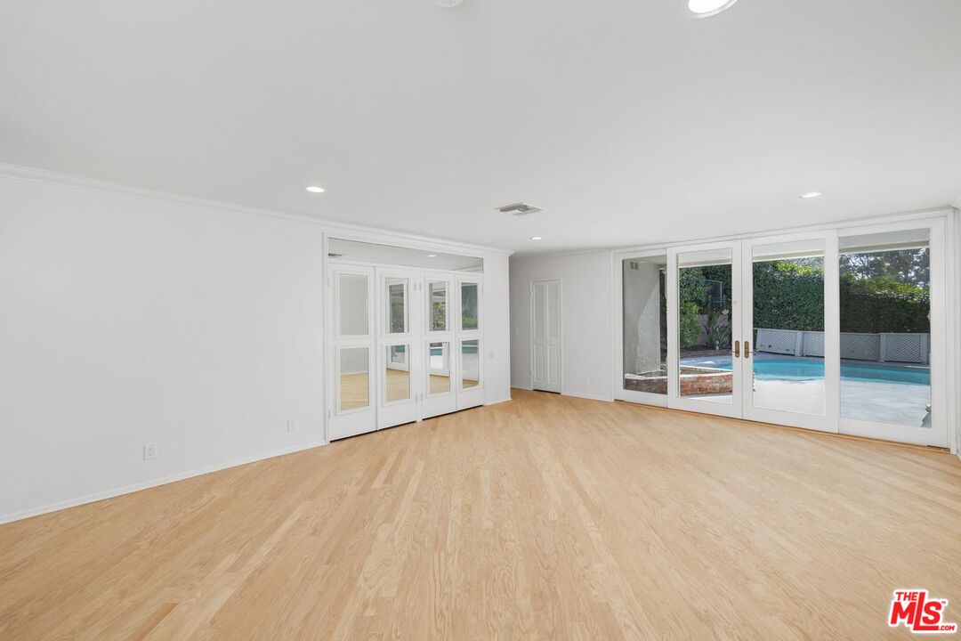 1700 Rising Glen Road Los Angeles, CA 90069 - Photo 9 of 19 a view of an empty room with wooden floor and a window