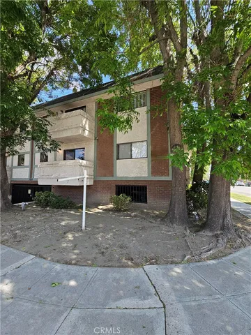 a view of a house with a yard and large tree