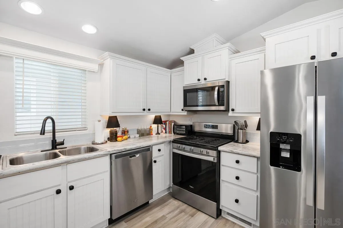 8545 Mission Gorge Road, Unit SPC 336A Santee, CA 92071 - Photo 12 of 28 a kitchen with appliances a sink cabinets and a window