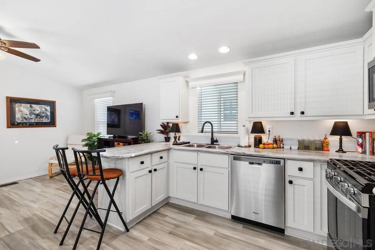 8545 Mission Gorge Road, Unit SPC 336A Santee, CA 92071 - Photo 13 of 28 a kitchen with a sink white cabinets and white appliances