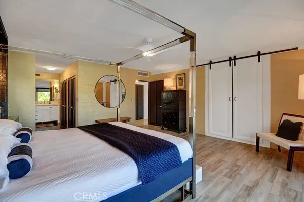 a bedroom with a bed large mirror and a desk