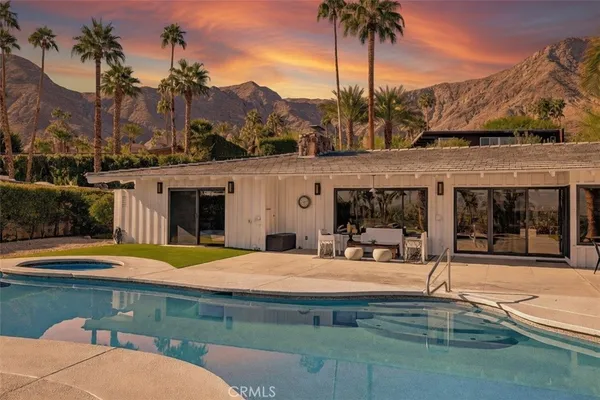 a swimming pool with outdoor seating and yard