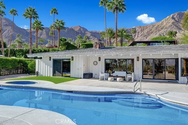 a swimming pool with outdoor seating and yard