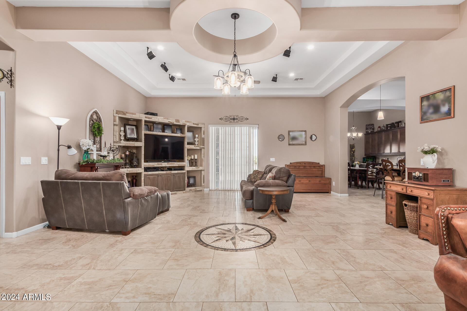 20716 West Telegram Path Road Buckeye, AZ 85326 - Photo 26 of 65 a living room with furniture a flat screen tv and a chandelier