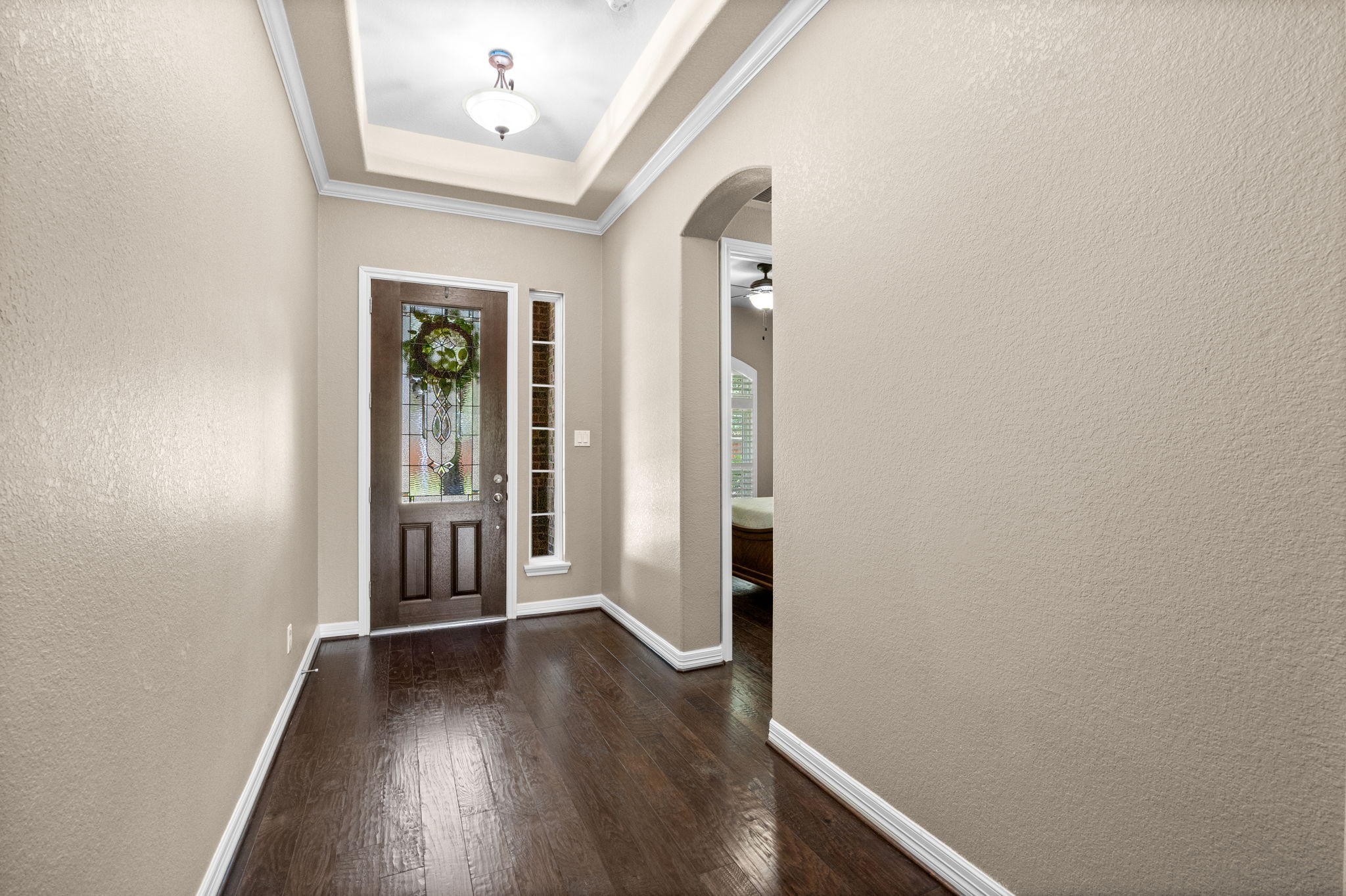 27642 Linden Ridge Lane Fulshear, TX 77441 - Photo 5 of 42
Looking back toward the Foyer, you'll appreciate the elegant, stained wood front door with its decorative glass insert. Through the graceful archway is the private wing of the home, featuring two Secondary Bedrooms and a well-appointed Full Bath, thoughtfully designed to provide comfort and privacy for family and guests.
