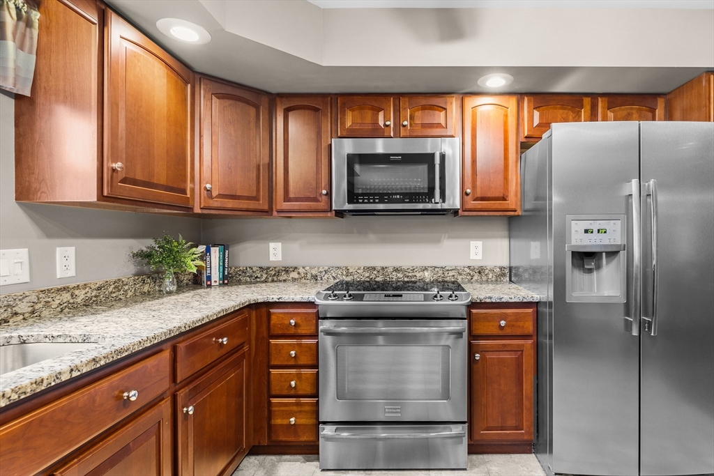 780 Dickinson Street Fall River, MA 02721 - Photo 12 of 42 a kitchen with stainless steel appliances granite countertop a refrigerator and a stove top oven