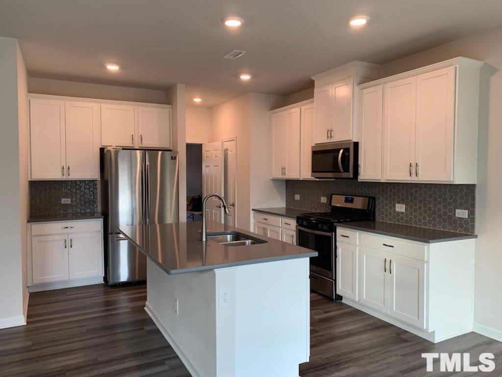 3413 Dropseed Drive Apex, NC 27502 - Photo 12 of 23 a kitchen with stainless steel appliances a refrigerator stove microwave and sink