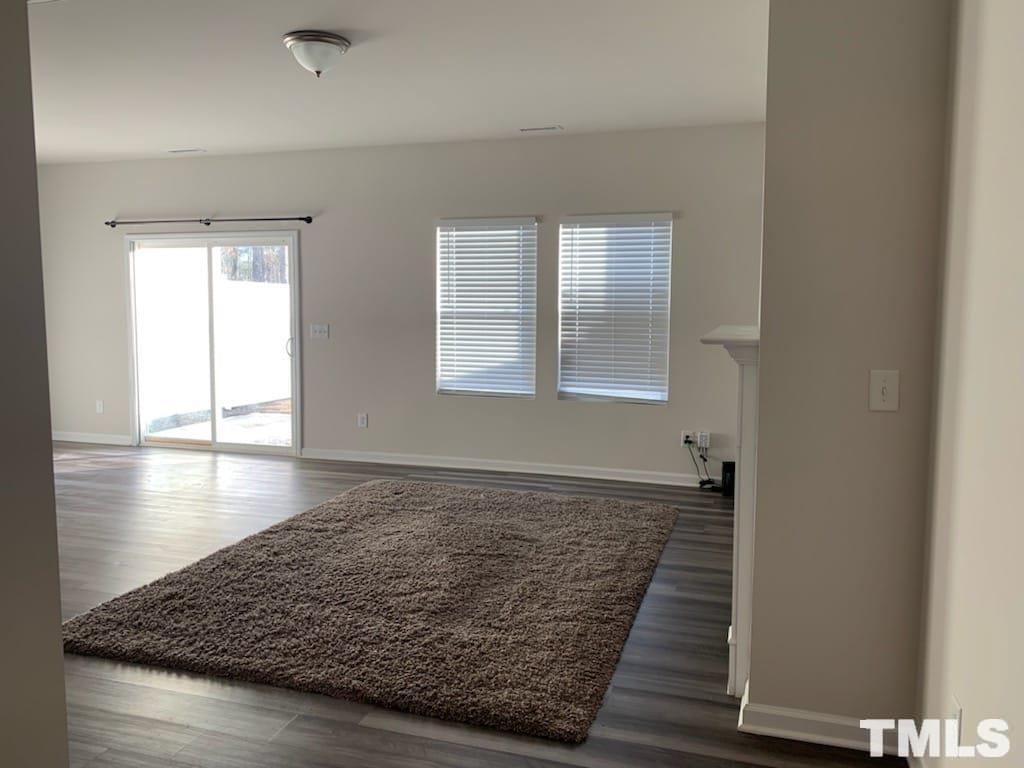 3413 Dropseed Drive Apex, NC 27502 - Photo 6 of 23 an empty room with wooden floor and windows