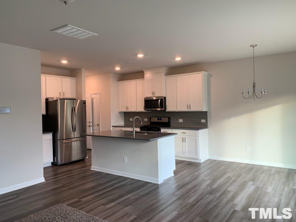 3413 Dropseed Drive Apex, NC 27502 - Photo 10 of 23 a kitchen with stainless steel appliances granite countertop a refrigerator and a stove top oven