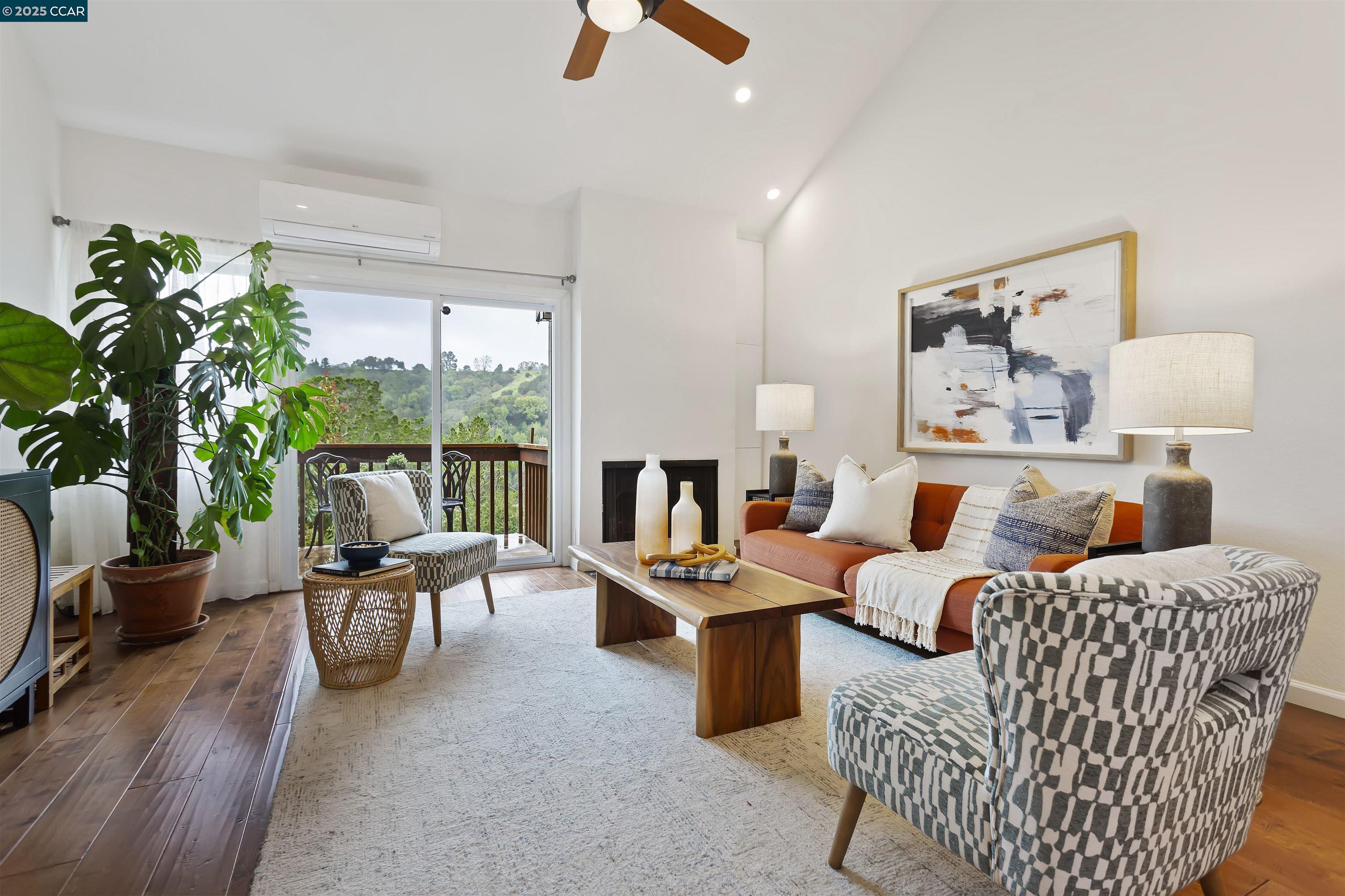 a living room with furniture fireplace and a large window