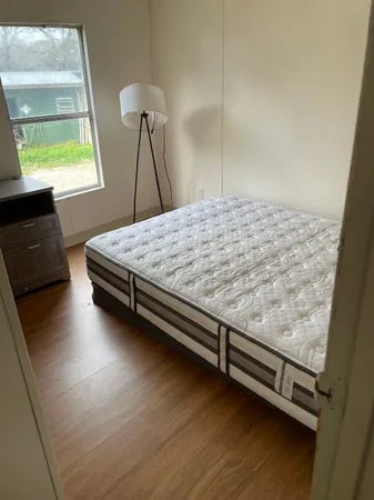 a bed sitting in a bedroom next to a window