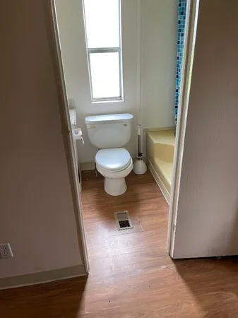 a bathroom with a toilet and a rug