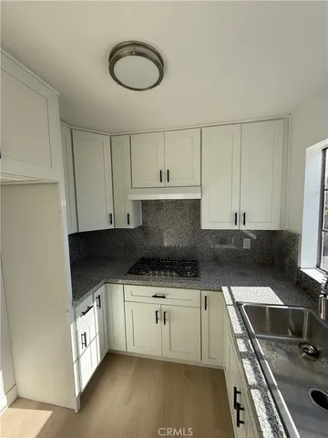 a kitchen with a sink a stove and cabinets