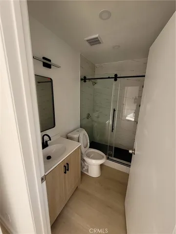 a white toilet sitting next to a bathroom sink and a shower