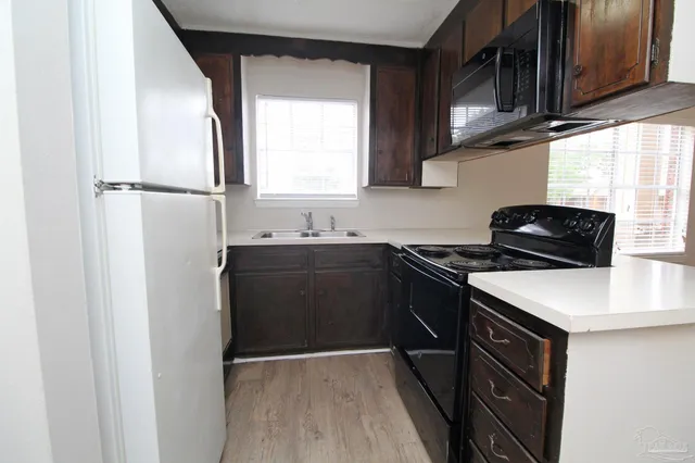 a kitchen with a sink a stove and cabinets