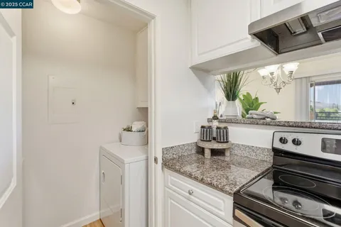 a kitchen with a sink and a stove with wooden floor
