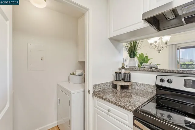 a kitchen with a sink and a stove with wooden floor