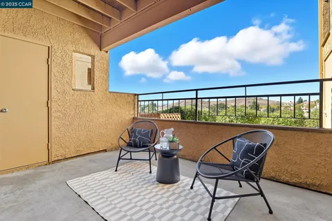 a balcony with table and chairs