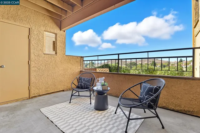 a balcony with table and chairs
