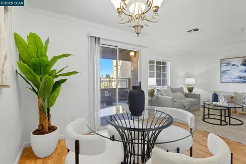 a living room with furniture a chandelier and a potted plant