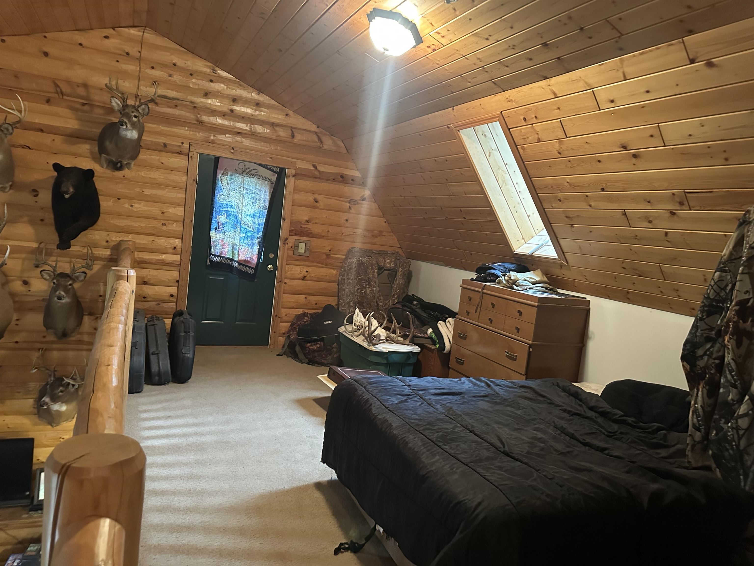 58875 Roy Anderson Road Mason, WI 54856 - Photo 17 of 26 Carpeted bedroom featuring vaulted ceiling, rustic walls, wooden ceiling, and a skylight