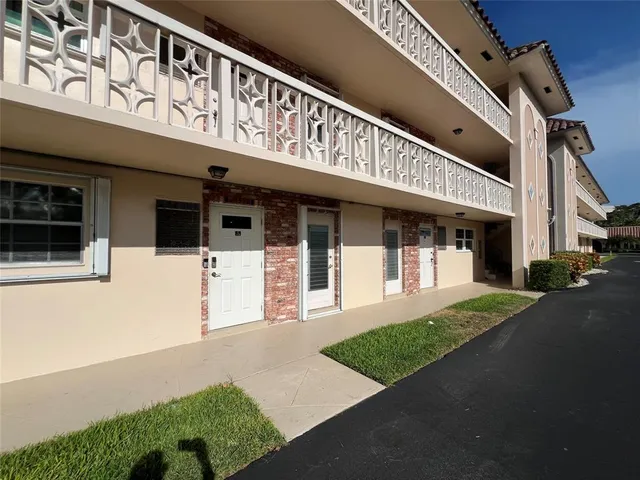 a front view of a building with a garden