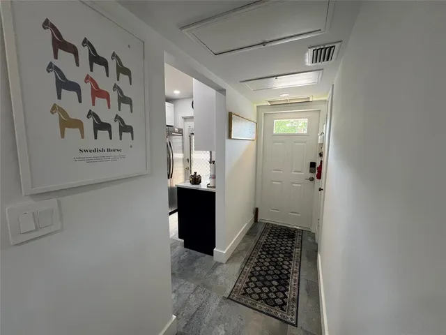 a walk in closet with wooden floor