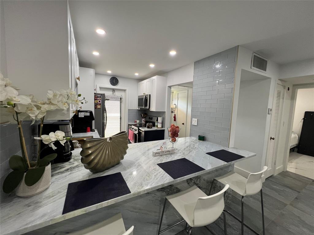 400 Northeast 20th Street, Unit C115 Boca Raton, FL 33431 - Photo 17 of 33 a living room with furniture and a chandelier