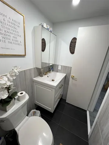 a bathroom with a sink mirror and toilet