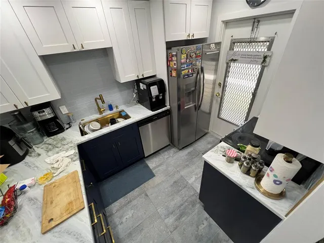 a kitchen with stainless steel appliances kitchen island granite countertop a refrigerator stove and sink