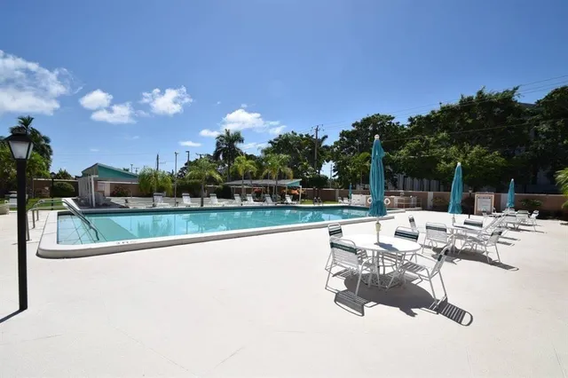 a view of swimming pool with outdoor seating and city in the background