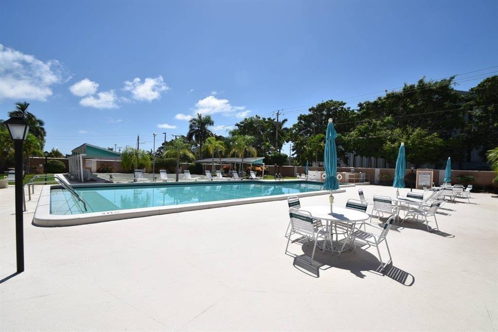 400 Northeast 20th Street, Unit C115 Boca Raton, FL 33431 - Photo 32 of 33 a view of swimming pool with outdoor seating and city in the background