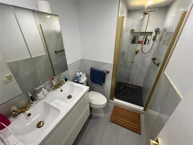 a bathroom with a sink and mirror with toilet