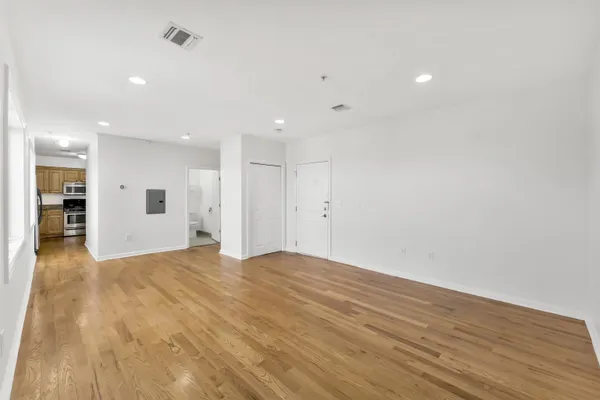a view of empty room with wooden floor and windows